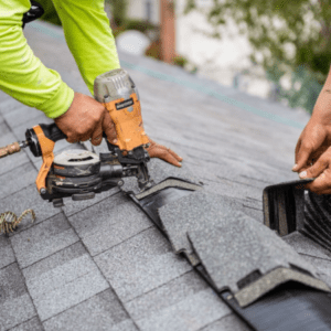 Using nail gun to attach roofing shingles