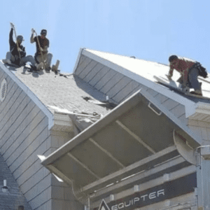 Team of contractors removing shingles off of roof to replace roofing