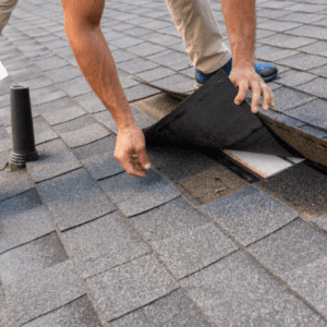 Contractor checking underneath roofing shingle